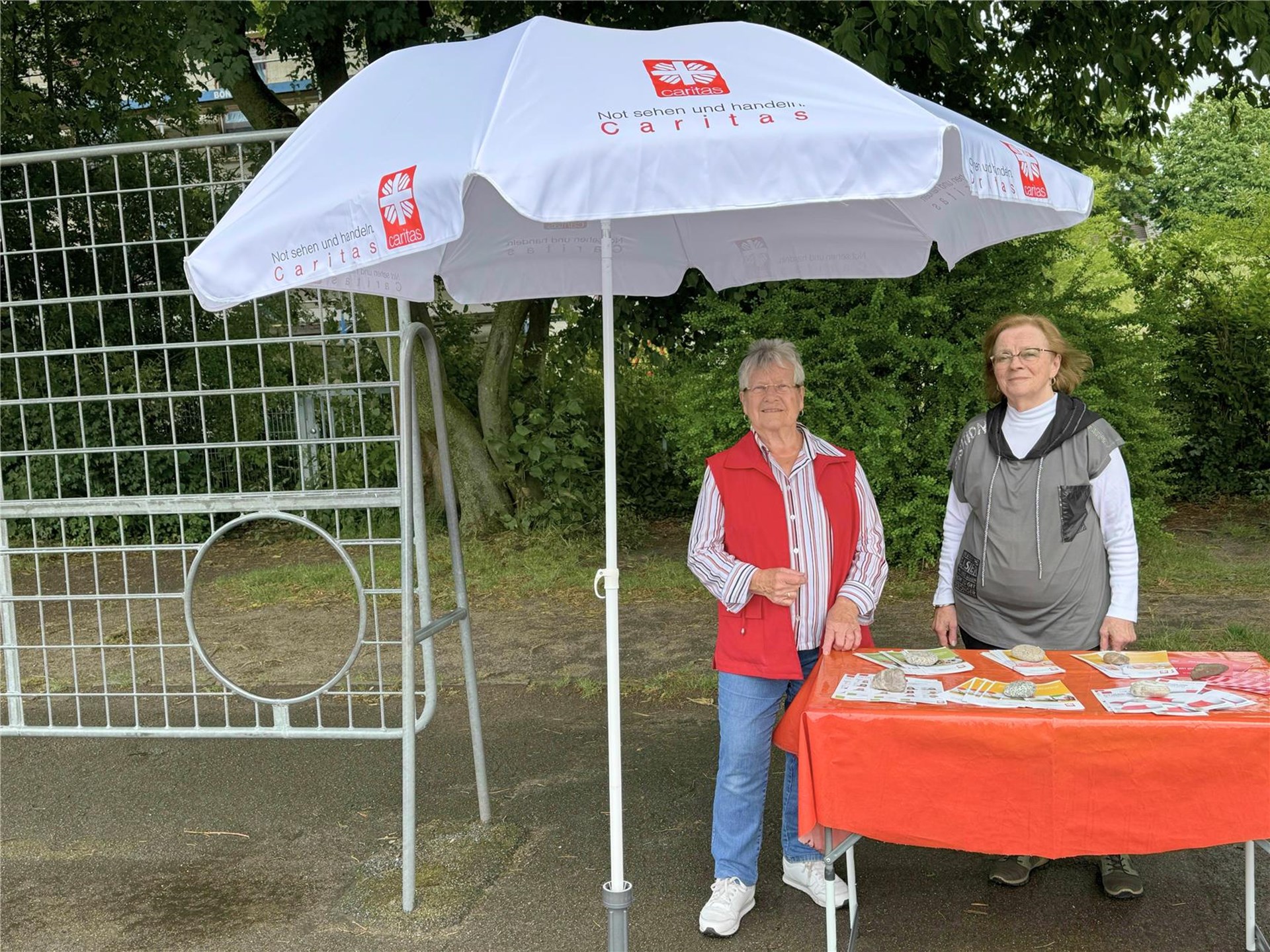 zwei Frauen stehen an einem Stand und vor einem Alu-Fußballtor