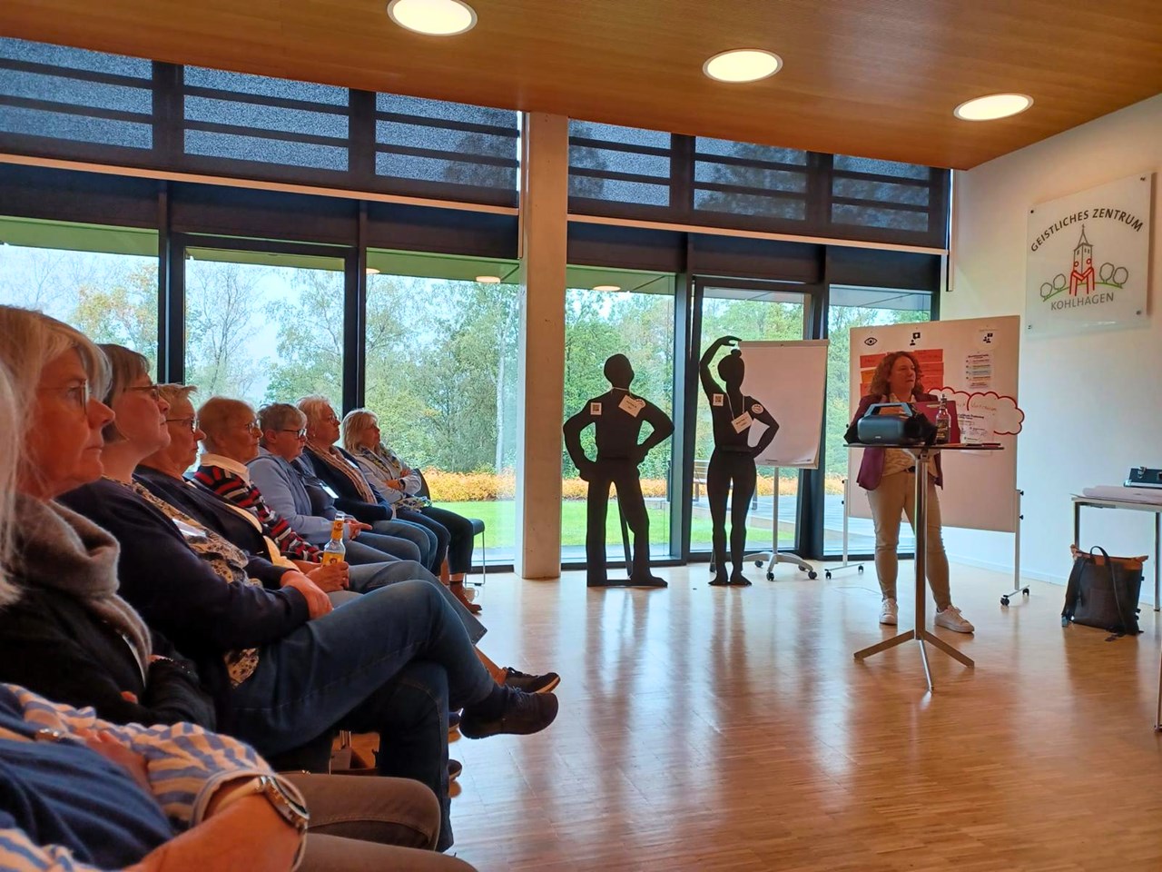 eine Frau hält einen Vortrag vor einer Gruppe