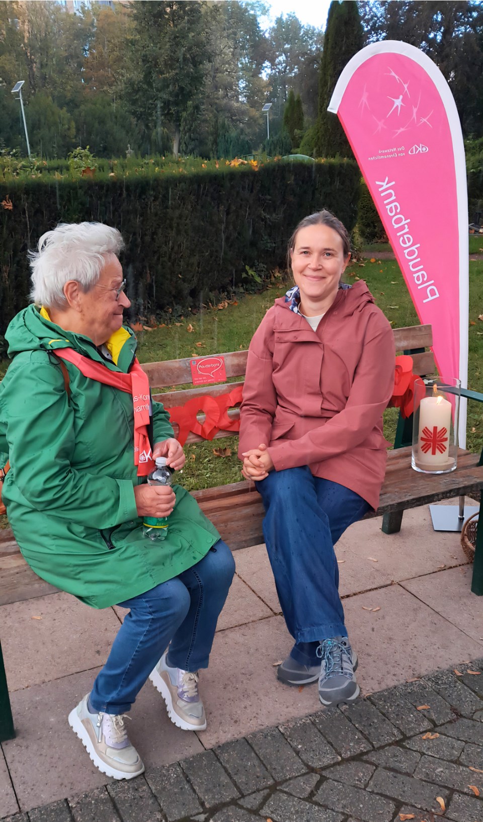 zwei Frauen unterhalten sich auf einer Bank