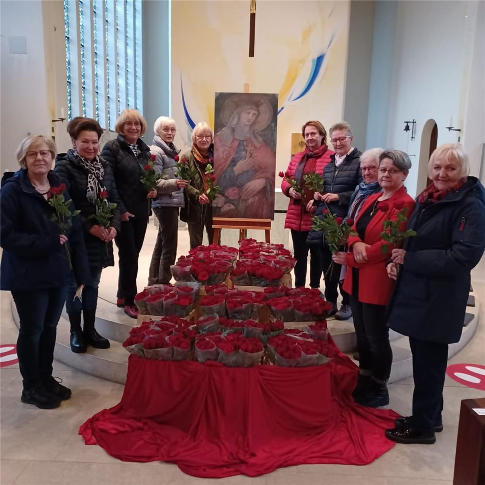 einige Frauen stehen mit Rosen vor dem Altar