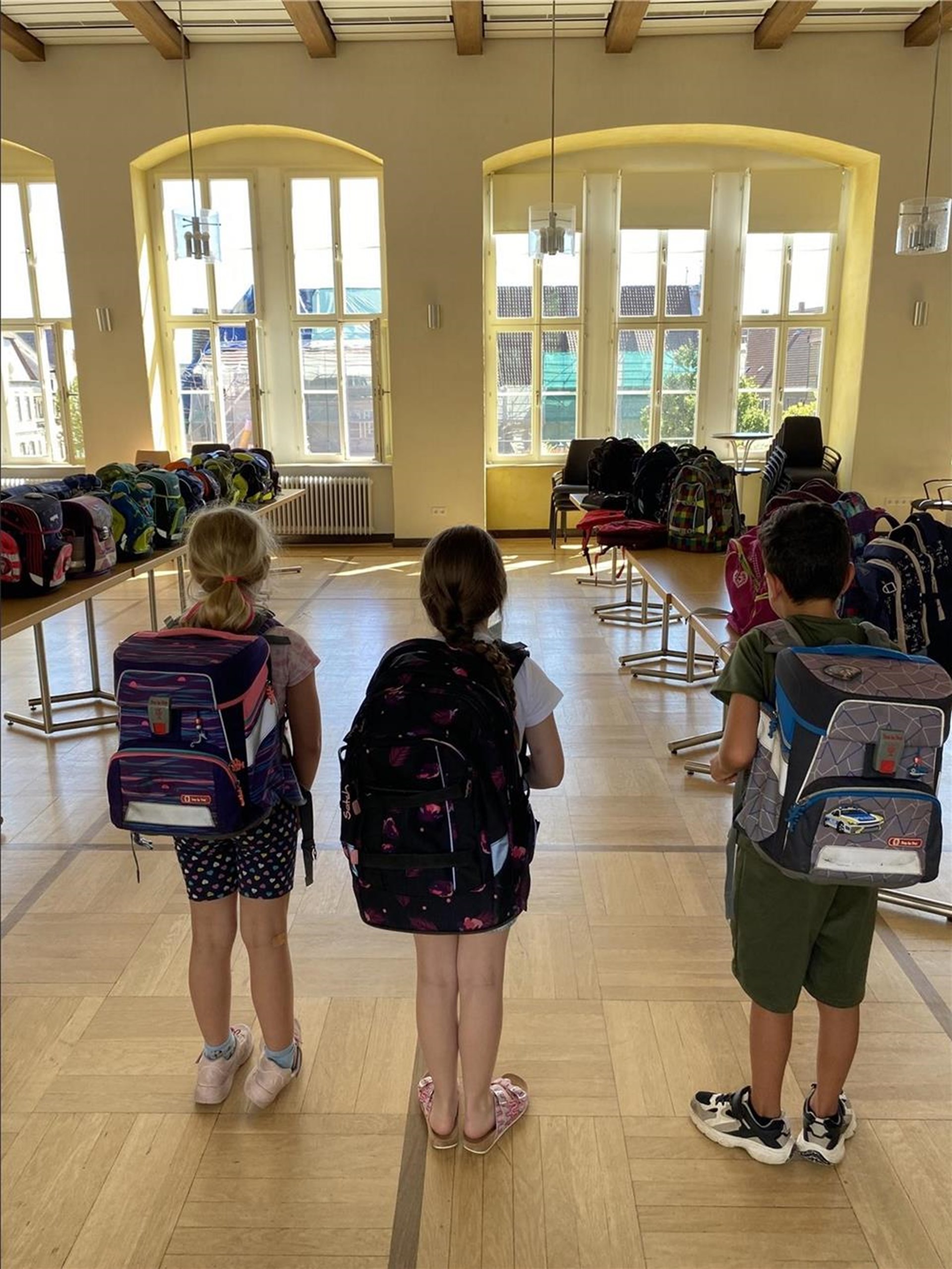 drei Kinder mit Schulranzen