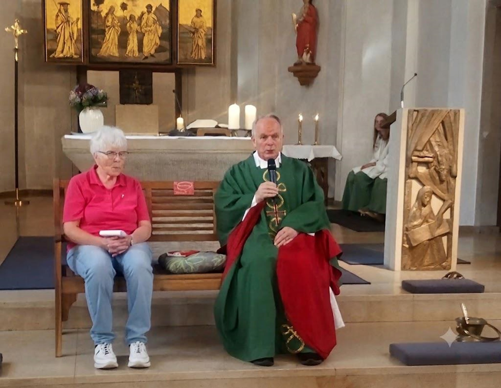 eine Frau und ein Pfarrer auf einer Bank in einer Kirche