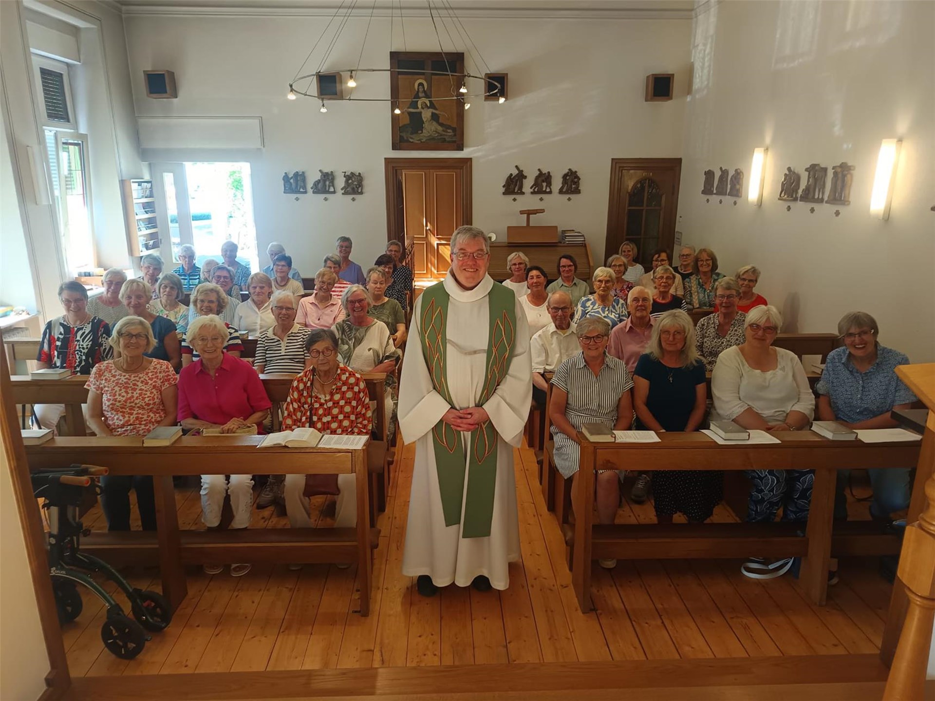 ein Priester steht in einer gefüllten Kapelle