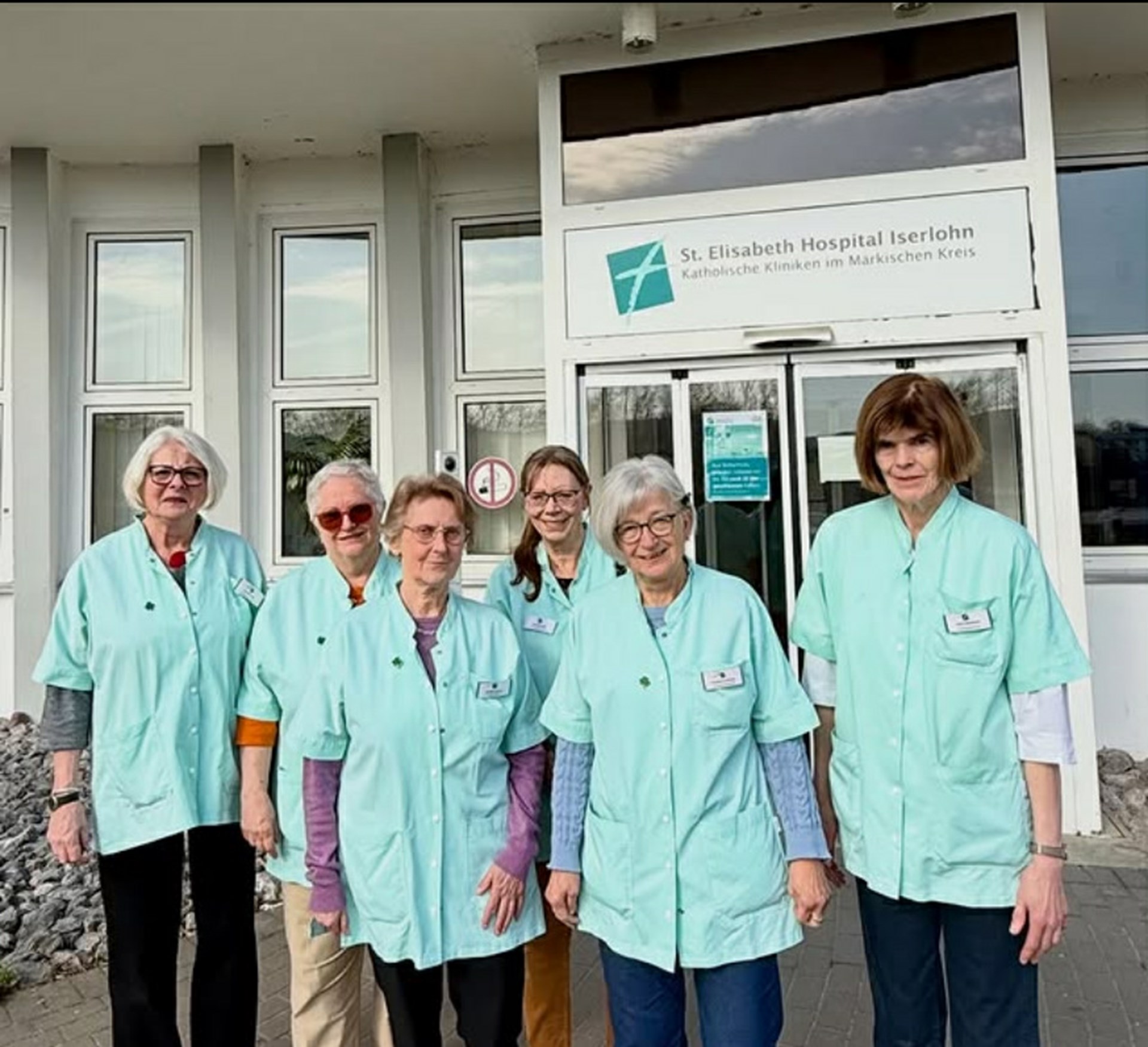 eine Gruppe Frauen im grünen Kittel